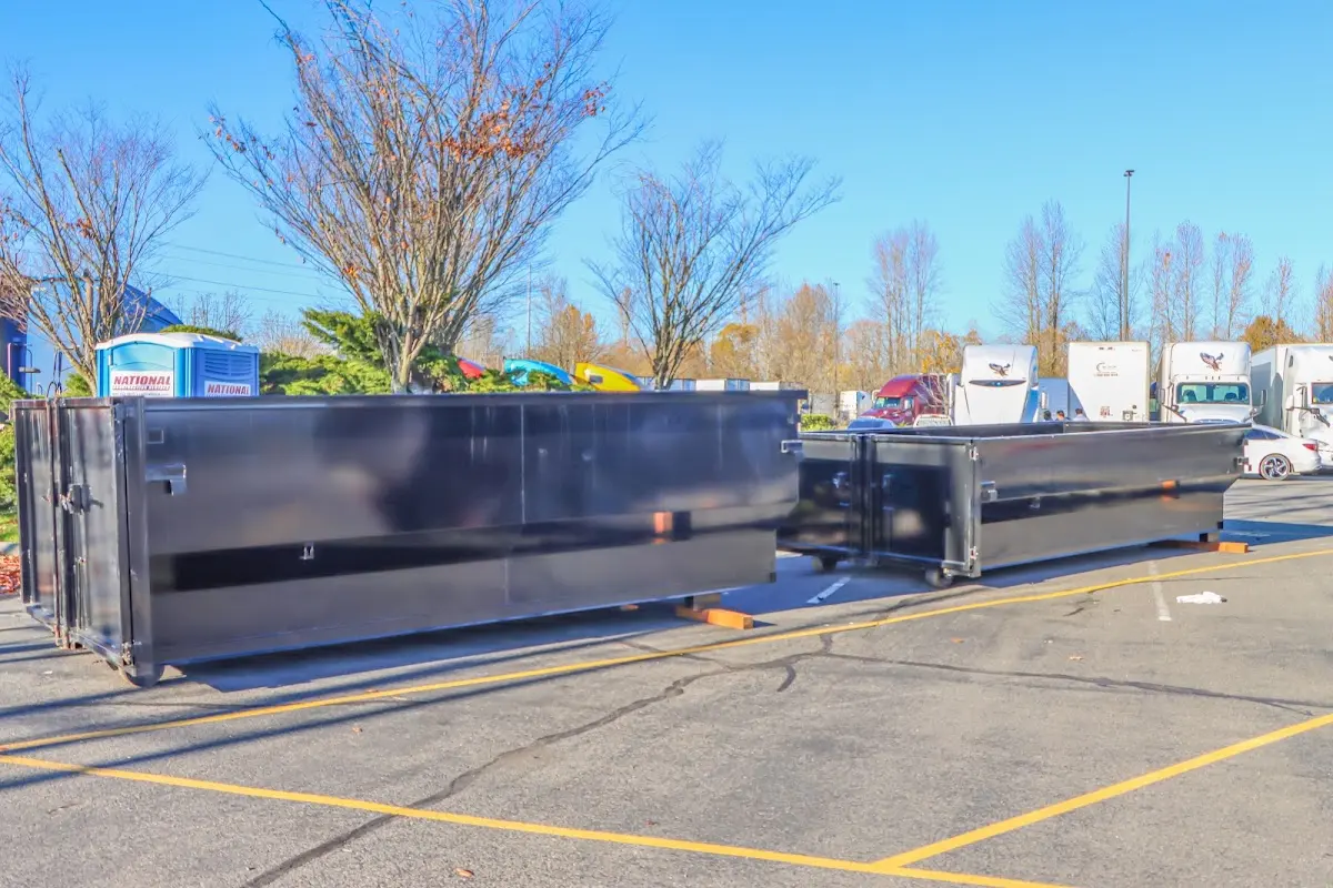 Professional dumpster rental service with roll-off container on residential driveway in Tracyton